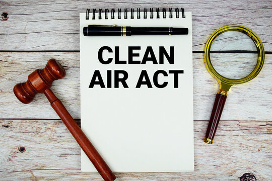 Clean Air Act text written on notepad with wooden judgment gavel and magnifying glass on wooden background