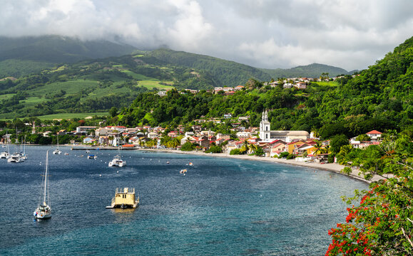 Beautiful view of Saint Pierre bay with boats anchored on the water, the historic town, and lush green hills in Martinique