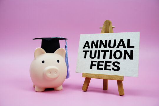 Annual Tuition Fees text with piggy bank waring graduation cap on pink background