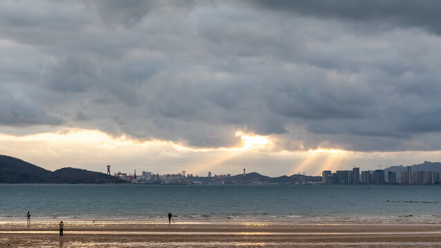 Coastal City Skyline Under Cloudy Sky With Sunbeams