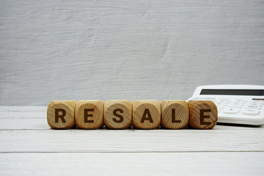 RESALE alphabet letters with calculator on wooden background