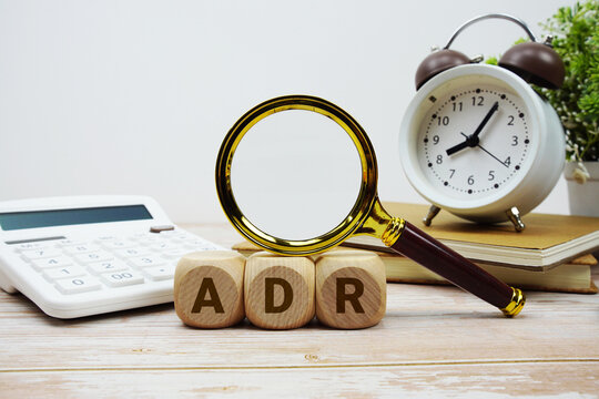 ADR American Depositary Receipt alphabet letters with magnifying glass, calculator and alarm clock