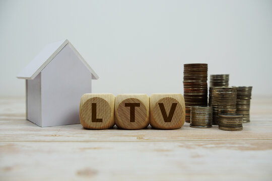 LTV (Loan To Value) text with house model and coin stack Properties and Real Estate Concept