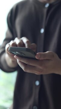 slow motion young man hand hold smartphone to surfing the internet and check work or mail on website while sit in the living room in weekend for business technology and lifestyle concept