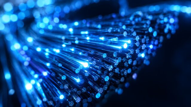 Fiber optic cables glow with bright blue light in a dark setting