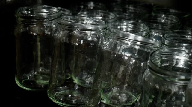 Medium shot of multiple clean empty glass jars arranged inside an oven undergoing heat sterilization prior to home canning and fruit preservation process