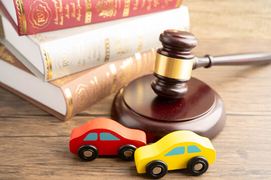 Car accident lawsuit and insurance, Judge hammer with car model.