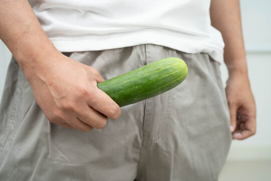 Male stands holding a banana, penis health.