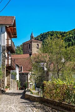 Strolling through Isaba in Roncal valley, Pyrenees, Navarre in Spain with brownish tiled roofs of residential buildings