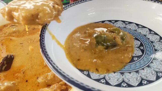 Warm creamy kari pakora Pakistani dish  soup being served with fresh herbs and spoon stirring in ceramic bowls with showcasing rich texture inviting aroma captures smooth golden ladled shallow ceramic