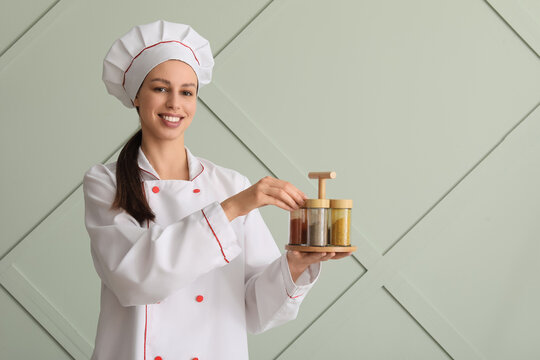 Culinary expertise and professional cooking, smiling female chef holding a spice rack with various seasonings in a modern kitchen environment