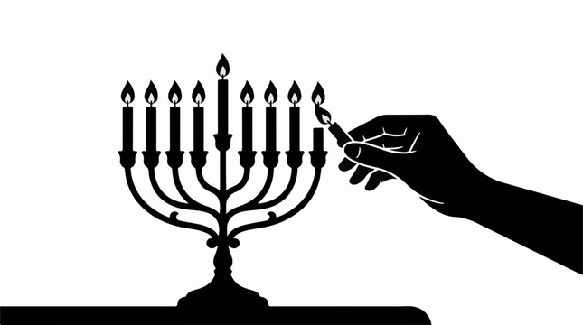 Silhouette of a hand lighting a candle on a nine branched menorah