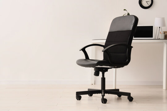 Remote work shift and corporate downsizing, empty office chair at a desk with laptop unemployment and job market instability in workplace