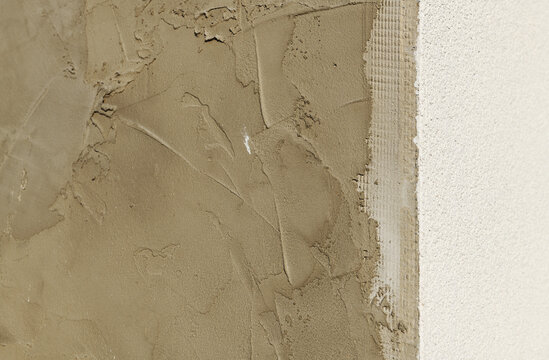Close up of wet cement plaster layer on a wall background.