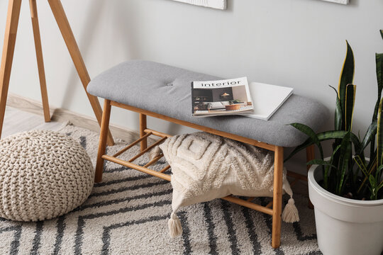 Grey bench with magazines and cushion in interior of hall, closeup