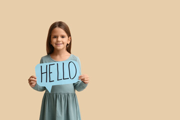 Cute little happy girl holding paper speech bubble with word HELLO on beige background © Pixel-Shot