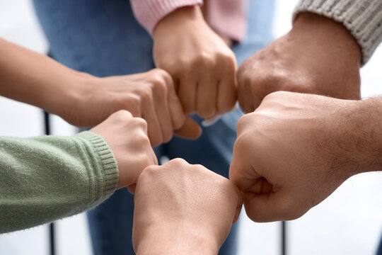 People bumping fists at group therapy session, closeup
