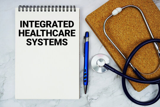 Integrated Healthcare Systems text written on notepad with stethoscope and alarm clock on marble background