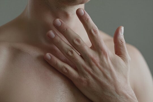 Captures Close Of Persons Upper Body Focusing On Neck Chest Area Individual To Male As Suggested By Stubble Chin Hair Skin Tone Fair