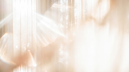 Obraz na płótnie Canvas Blurred sheer window curtains filtering warm morning sunlight creating glowing optical lens flare effects across abstract beige horizontal interior room wall