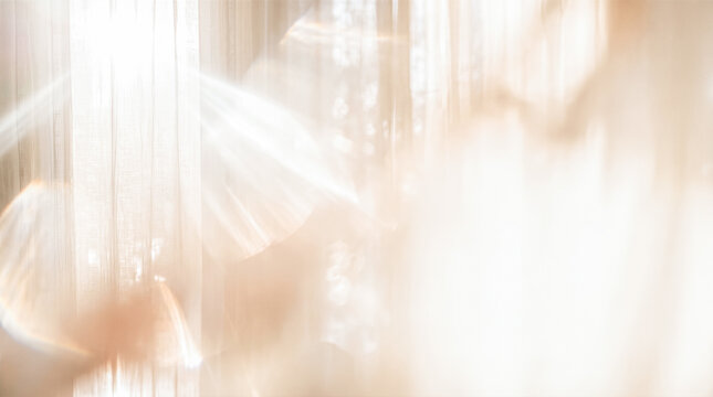 Blurred sheer window curtains filtering warm morning sunlight creating glowing optical lens flare effects across abstract beige horizontal interior room wall