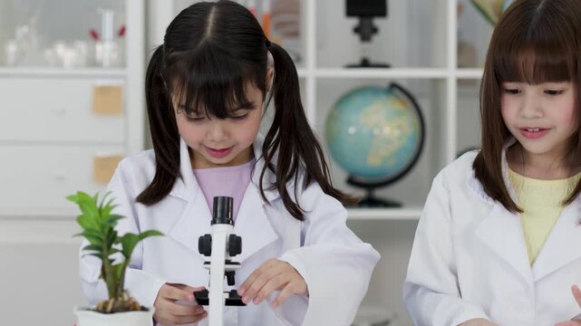 Elementary Students in Lab Coats Using Microscope in Science Class