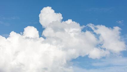 Soft white clouds drift against a vibrant blue sky © schankz