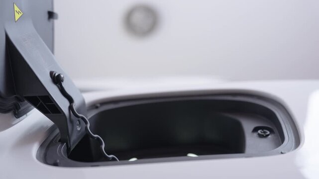 Hand of woman plugs the charging cable of an electric vehicle (EV car), Sustainable clean energy