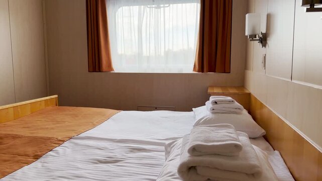 A cozy bed sits ready inside a cruise ship cabin on the Neva River. It invites travelers to rest and feel peaceful. The warm room creates a calm mood.