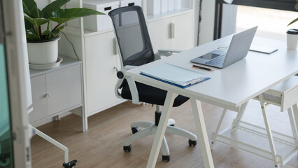 Modern minimalist home office workspace with a laptop and ergonomic chair in bright room © Naypong Studio