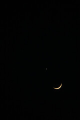 Slender crescent moon in very close conjunction with the bright planet Venus in the night sky.  © Joshua Prasetyadi
