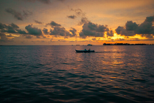 Fishing boat on the sea at tropical sunset with offshore island, Makassar, Sulawesi, Indonesia