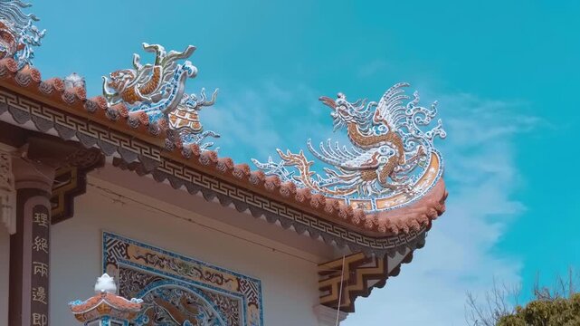 Intricate, multi-tiered curved pagoda roof built in traditional Vietnamese style features detailed dragon sculptures, which serve as guardian figures protecting  structure and typical roofing element