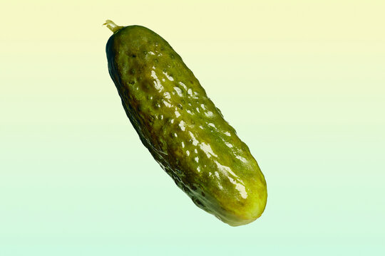 Close up of pickled cucumber floating on yellow and green background