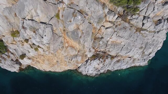 Aerial drone view of rugged sea cliffs and steep rocky coast with untouched natural terrain.