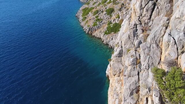 Aerial drone view of rugged sea cliffs and steep rocky coast with untouched natural terrain.