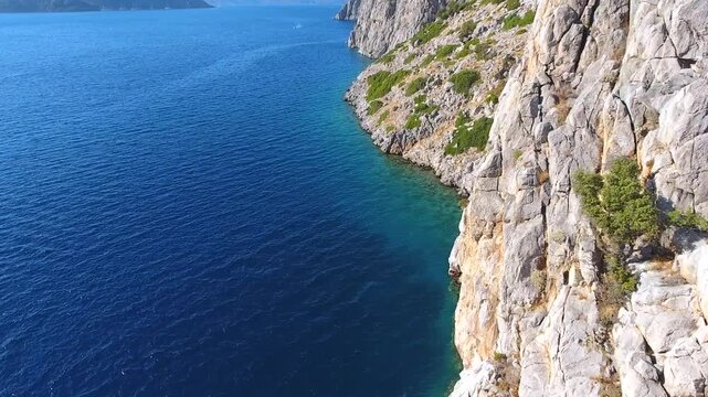Aerial drone view of rugged sea cliffs and steep rocky coast with untouched natural terrain.
