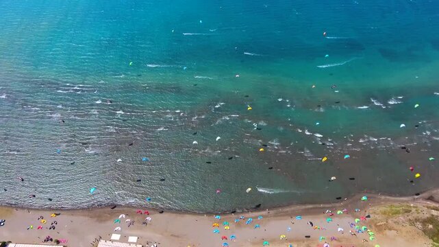 Aerial drone view of kiteboarders in Akyaka Gokova Bay Turkey with wind, waves, and beach.