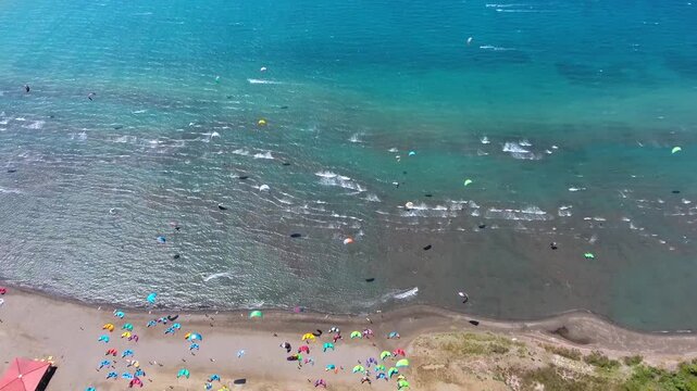 Aerial drone view of kiteboarders in Akyaka Gokova Bay Turkey with wind, waves, and beach.