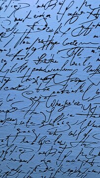 Abstract closeup of vintage cursive handwriting in black ink on a cool blue textured background for creative design projects.