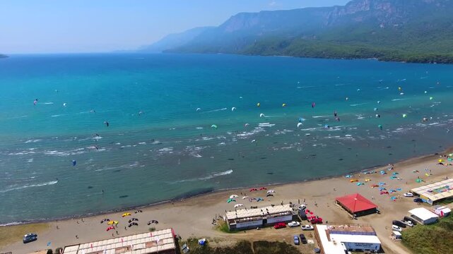 Aerial drone view of kiteboarders in Akyaka Gokova Bay Turkey with wind, waves, and beach.