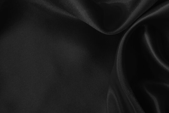 Black fabric cloth texture for background and design art work, beautiful crumpled pattern of silk or linen.