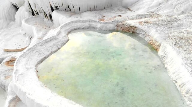 Aerial drone view of Pamukkale travertine pools in Denizli Turkey with white limestone bowls.