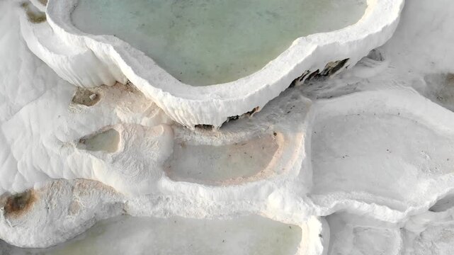 Aerial drone view of Pamukkale travertine pools in Denizli Turkey with white limestone bowls.