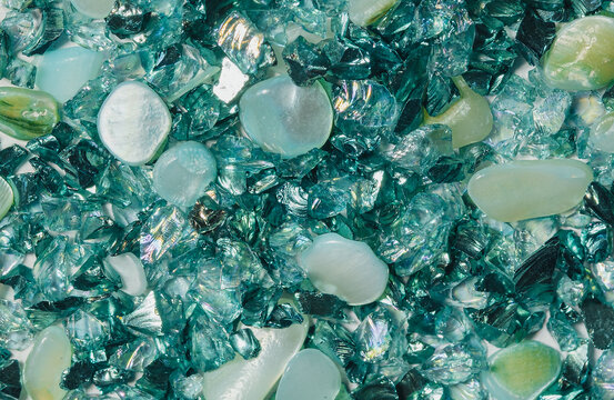 Close up of iridescent mother of pearl shell chips mixed with transparent and metallic decorative fragments