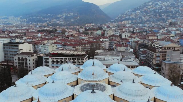 Aerial drone view of Bursa Ulu Mosque in Turkey with domes, minarets, and Ottoman form.