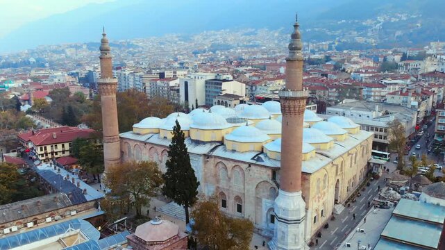 Aerial drone view of Bursa Ulu Mosque in Turkey with domes, minarets, and Ottoman form.