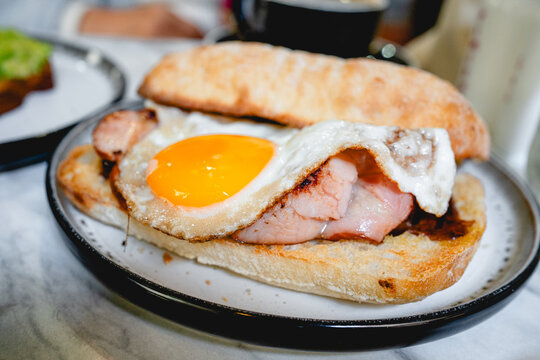 Bacon and Egg Roll Served on a Plate in a Caf&eacute;