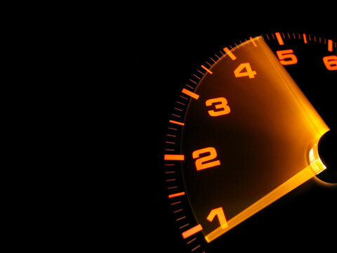 Detail of modern car dashboard instrument cluster with orange numbers