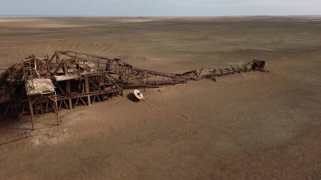 An abandoned, rusty oil drilling platform on the Skeleton Coast (Namibia, Africa). Drone view.